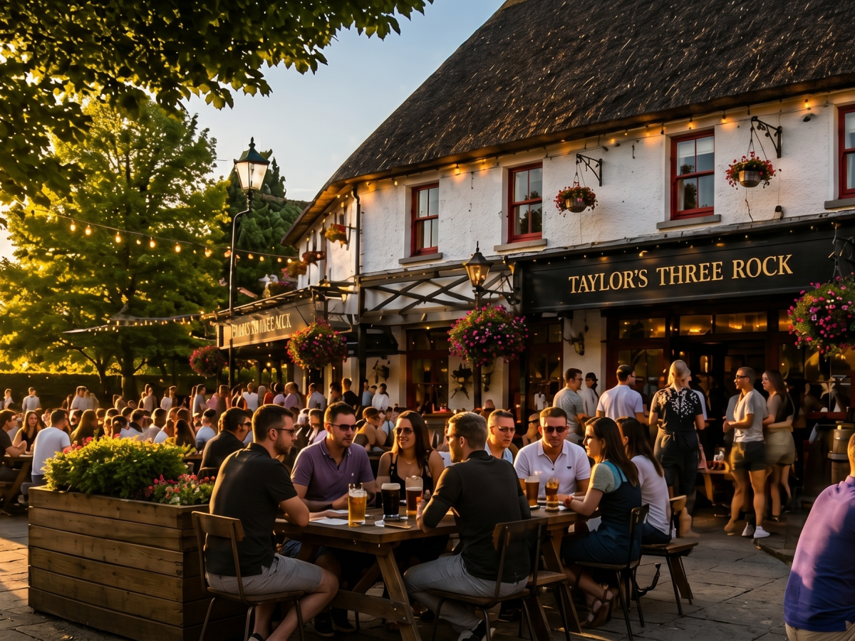 Crowd at outdoor tables by a rustic pub during sunset.